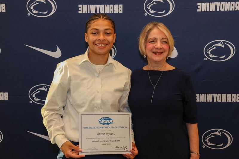 student holding award with Chancellor Wells